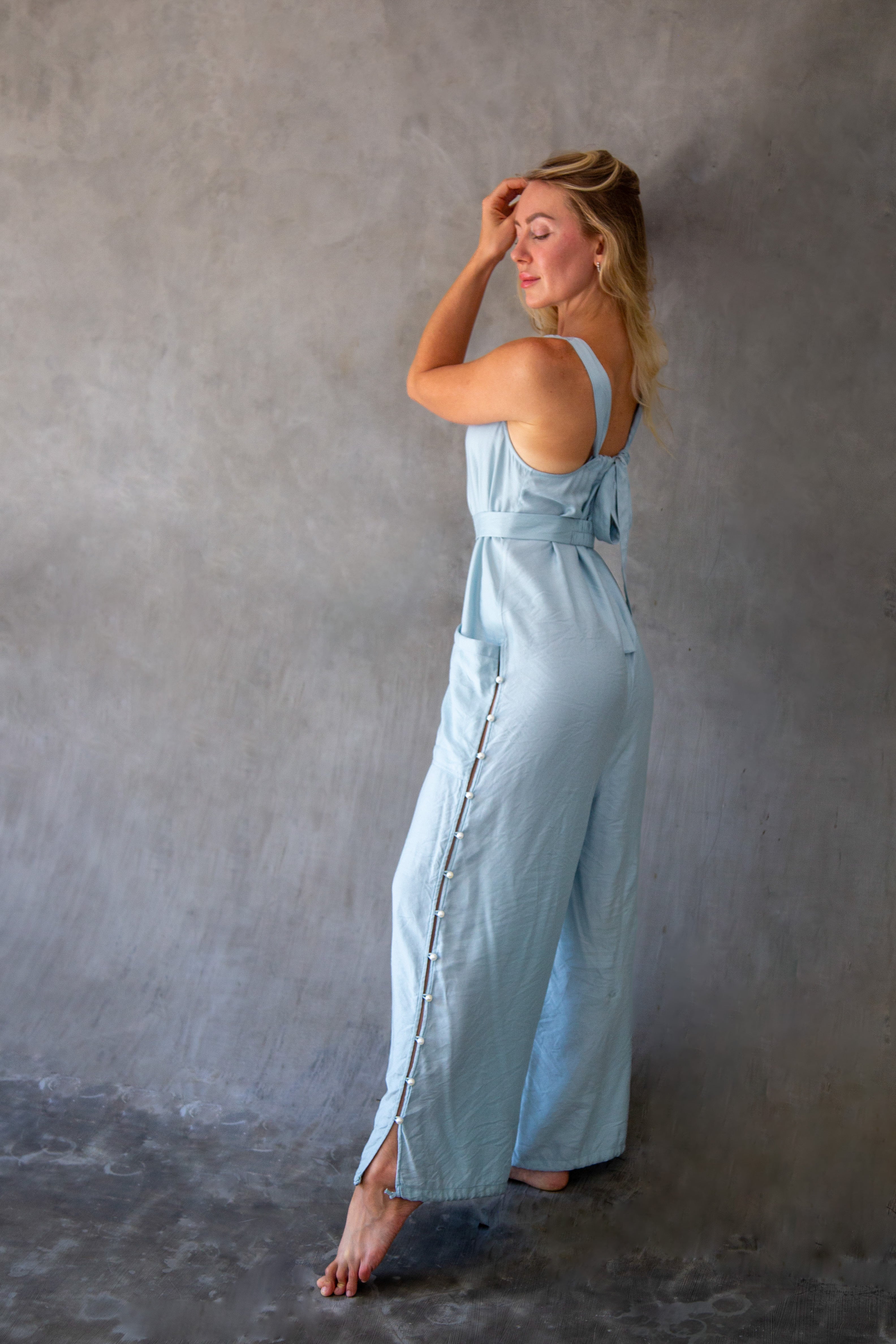 Elegant back silhouette in sky blue evening resort jumpsuit